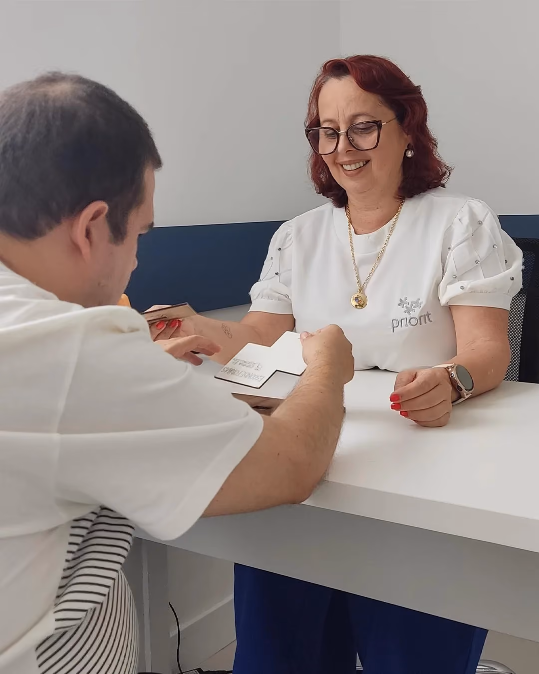Psicopedagoga y alumno en una actividad con tarjetas sobre la mesa.