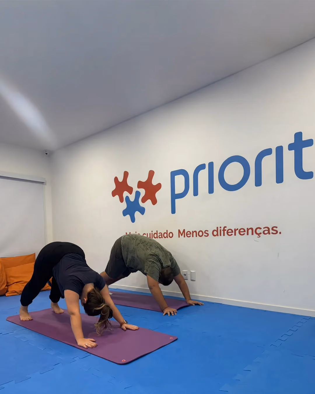 Pair in downward-facing dog pose during the yoga class.