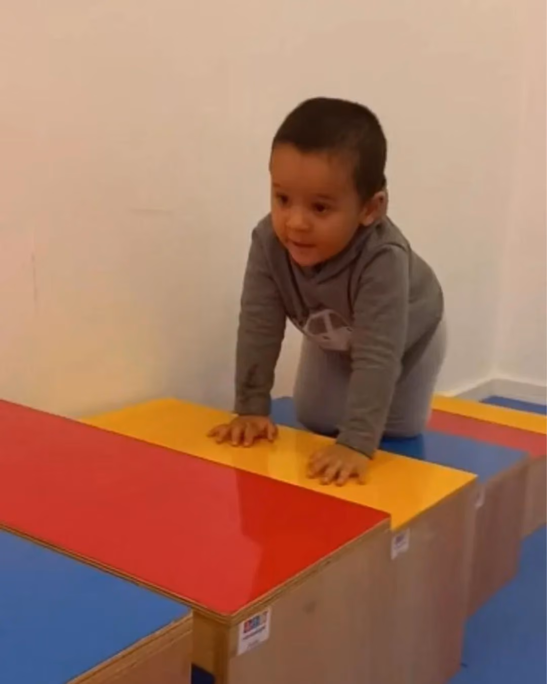 Criança apoiando as mãos em um módulo de espuma durante o circuito psicomotor.