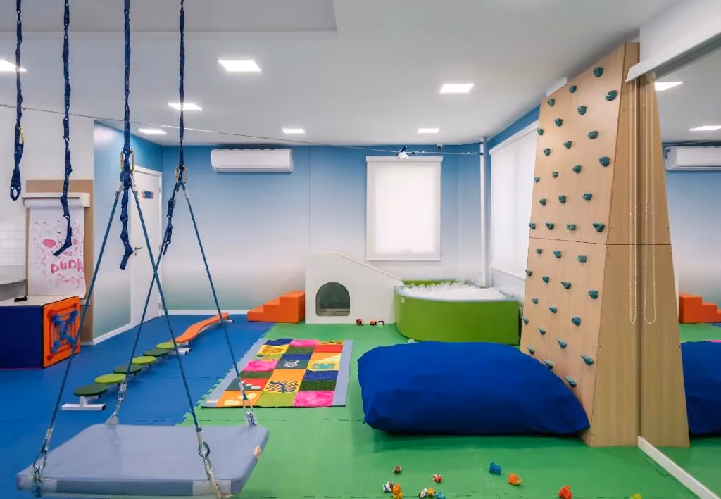 Sala de integração sensorial equipada com balanços suspensos e almofadas. - 2 de 6